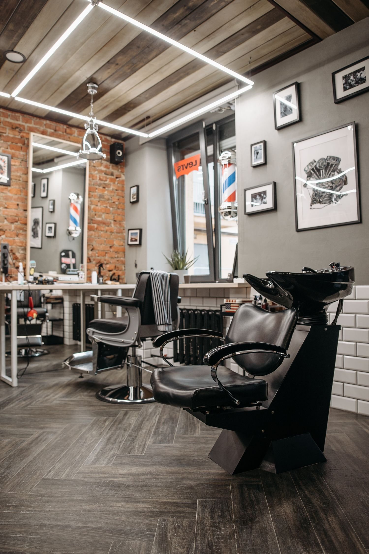 Interior da barbearia com cadeiras de couro e espelhos